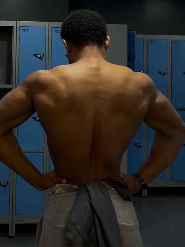 Salem Alawi's muscular back, photographed in a gym changing room mirror